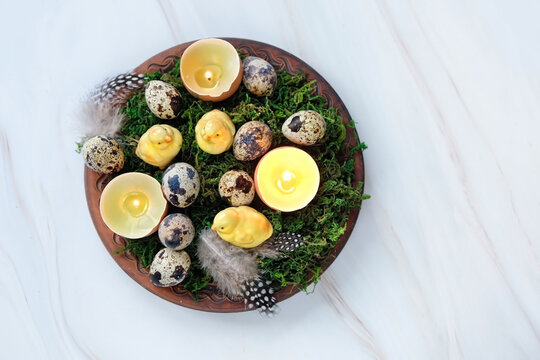 Easter composition - plate with moss, Easter eggs and diy candles in eggs shells, chickens. symbol Ostara or Easter holiday. festive spring season. flat lay