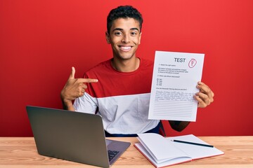 Young handsome african american man showing failed exam pointing finger to one self smiling happy...
