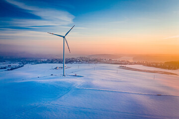 Wind turbine and snowy field in winter. Alternative energy, Poland. © shaiith