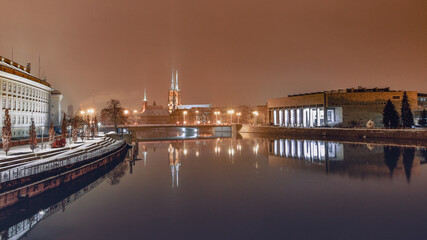 Fototapeta na wymiar The University Library in Wroclaw on the banks of the Odra River, illuminated at night.