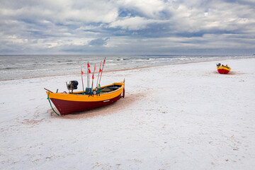Fishing boat on snowy beach, winter Baltic sea, aerial view