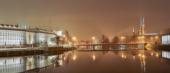The Peace Bridge in Wroclaw over the Odra River, illuminated at night.