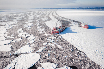 Icebreakers crushing ice on Vistula river in winter, Poland, Plock