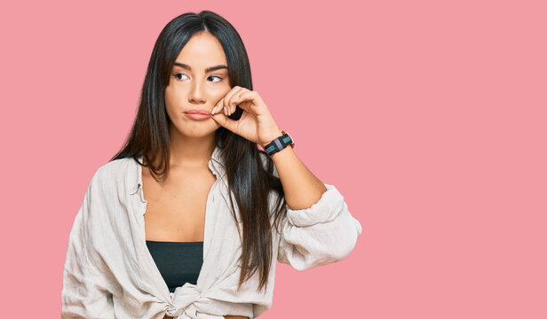 Young beautiful hispanic girl wearing casual clothes mouth and lips shut as zip with fingers. secret and silent, taboo talking
