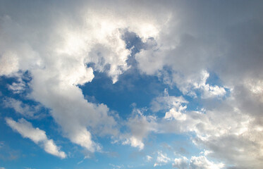 White cotton-textured clouds spread across a blue sky to the horizon