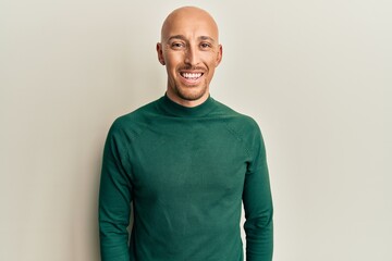 Bald man with beard wearing casual turtleneck sweater with a happy and cool smile on face. lucky person.