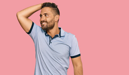 Obraz premium Handsome man with beard wearing casual clothes smiling confident touching hair with hand up gesture, posing attractive and fashionable