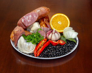 Typically Brazilian feijoada, ingredients, pepperoni sausage, garlic, paio, pepper, pork, black beans, bay leaf, cracklings and caipirinha with lemon and cachaça