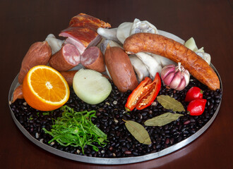 Typically Brazilian feijoada, ingredients, pepperoni sausage, paio, pepper, pork, black beans, bay leaf, cracklings and caipirinha with lemon and cacha&ccedil;a