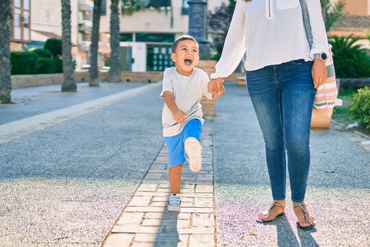 Adorable latin mother and son walking at the city.
