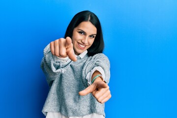 Young hispanic woman wearing casual clothes pointing to you and the camera with fingers, smiling positive and cheerful