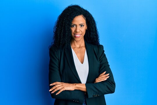 Middle age african american woman wearing business clothes happy face smiling with crossed arms looking at the camera. positive person.