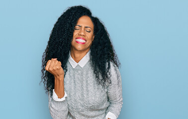 Middle age african american woman wearing casual clothes celebrating surprised and amazed for success with arms raised and eyes closed. winner concept.