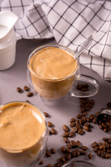 Dalgona Coffee. Whipped icing drink with instant coffee popular in Korea Creamy cocktailin a transparent double wall glass mug.