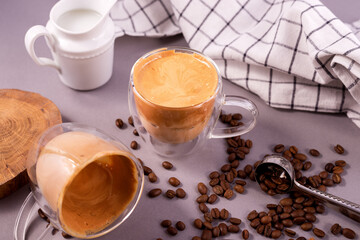 Dalgona Coffee. Whipped icing drink with instant coffee popular in Korea Creamy cocktailin a transparent double wall glass mug.