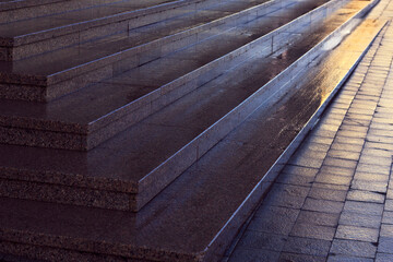 wet red granite stairs and city pavement pattern -  textured background with beautiful light, city parallel lines with warm light and cold shadow