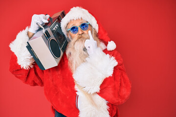 Old senior man wearing santa claus costume and boombox serious face thinking about question with hand on chin, thoughtful about confusing idea