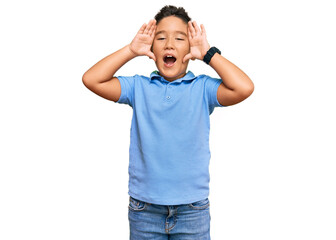 Little boy hispanic kid wearing casual clothes smiling cheerful playing peek a boo with hands showing face. surprised and exited