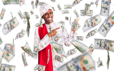 African handsome man wearing tradition sherwani saree clothes pointing aside worried and nervous...
