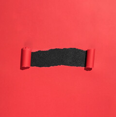 Red paper opened ripped to reveal black copy space. Paper ripping into scrolls, opening window in...