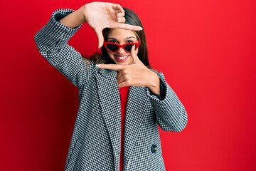 Young brunette woman wearing fashion and modern look smiling making frame with hands and fingers...