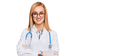 Beautiful caucasian woman wearing doctor uniform and stethoscope happy face smiling with crossed arms looking at the camera. positive person.