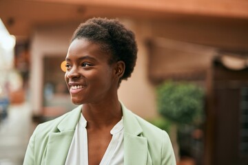 Obraz premium Young african american businesswoman smiling happy standing at the city