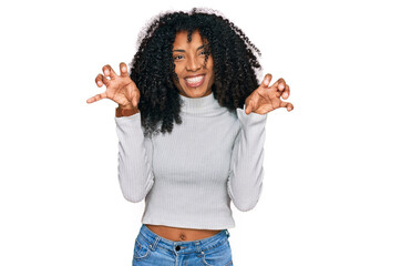 Young african american girl wearing casual clothes smiling funny doing claw gesture as cat,...