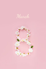 Numeral 8 made of spring sakura flowers on pink background. Creative concept of Women's Day. Vertical postcad