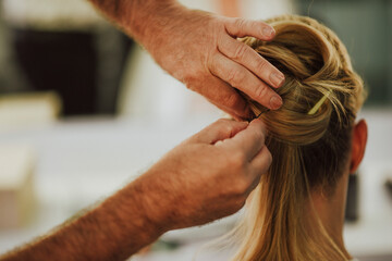 Caucasian hairdresser man doing a wedding bow to a young blond Caucasian woman