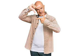 Middle age bald man wearing casual clothes smiling making frame with hands and fingers with happy face. creativity and photography concept.