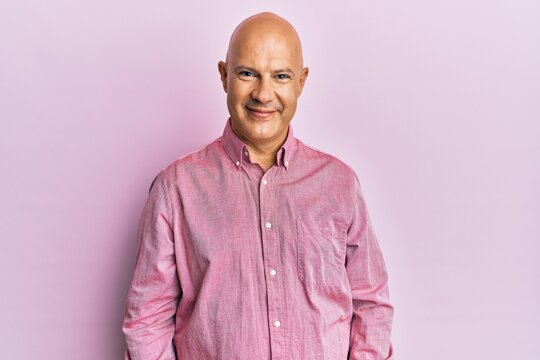 Middle age bald man wearing pink business shirt with a happy and cool smile on face. lucky person.