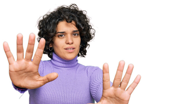 Young hispanic woman with curly hair wearing casual clothes doing stop gesture with hands palms, angry and frustration expression
