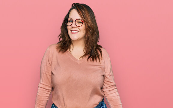 Young plus size woman wearing casual clothes and glasses winking looking at the camera with sexy expression, cheerful and happy face.