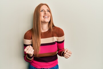 Young irish woman wearing casual clothes very happy and excited doing winner gesture with arms raised, smiling and screaming for success. celebration concept.