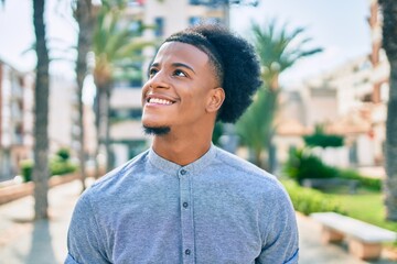 Young african american man smiling happy walking at the city.