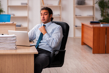 Fototapeta premium Young male employee unhappy with excessive work