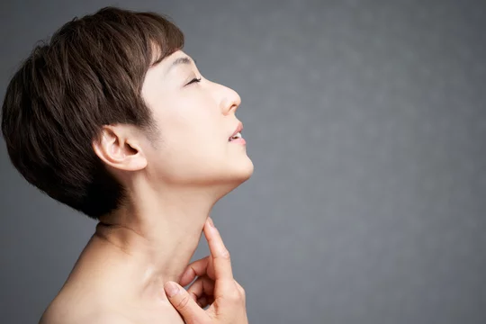 首筋を押さえる中年の日本人女性stock Photo Adobe Stock