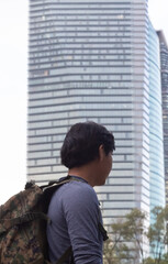 man with backpack going to work in office building