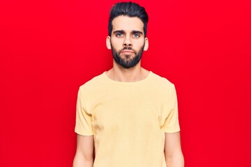 Fototapeta premium Young handsome man with beard wearing casual t-shirt with serious expression on face. simple and natural looking at the camera.
