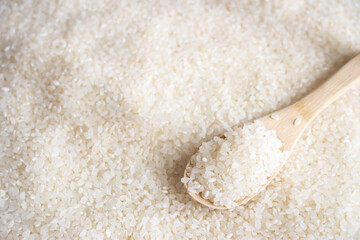 白米の背景と、木のスプーン