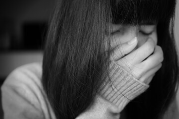 Fototapeta premium Blur and black and white image of close up woman cry and cover your face with your hands. she is sad because of thedisappointment of love. broken heart concept.