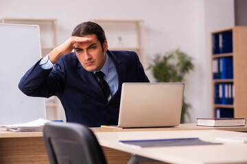 Young male employer sitting in the office