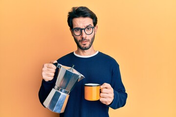 Young hispanic man drinking italian coffee skeptic and nervous, frowning upset because of problem. negative person.
