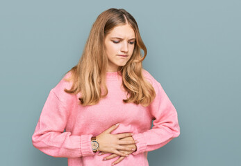 Beautiful young caucasian girl wearing casual winter sweater with hand on stomach because indigestion, painful illness feeling unwell. ache concept.