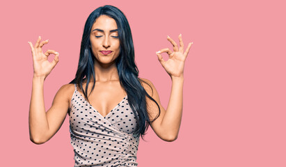 Beautiful hispanic woman wearing summer dress relax and smiling with eyes closed doing meditation gesture with fingers. yoga concept.