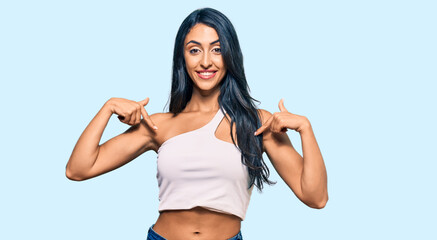 Obraz premium Beautiful hispanic woman wearing casual clothes looking confident with smile on face, pointing oneself with fingers proud and happy.