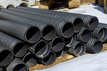 Plastic PVC pipes stacked in rows at a construction site on reconstruction of the city drain system