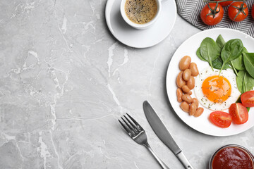 Tasty breakfast with fried egg, beans and coffee served on grey marble table, flat lay. Space for text
