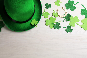 Flat lay composition with leprechaun hat on white wooden table, space for text. St Patrick's Day...